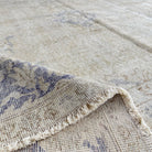 Close-up of the blue vintage Turkish medallion rug showing neutral details, hand-knotted weave, wool and cotton and low pile.