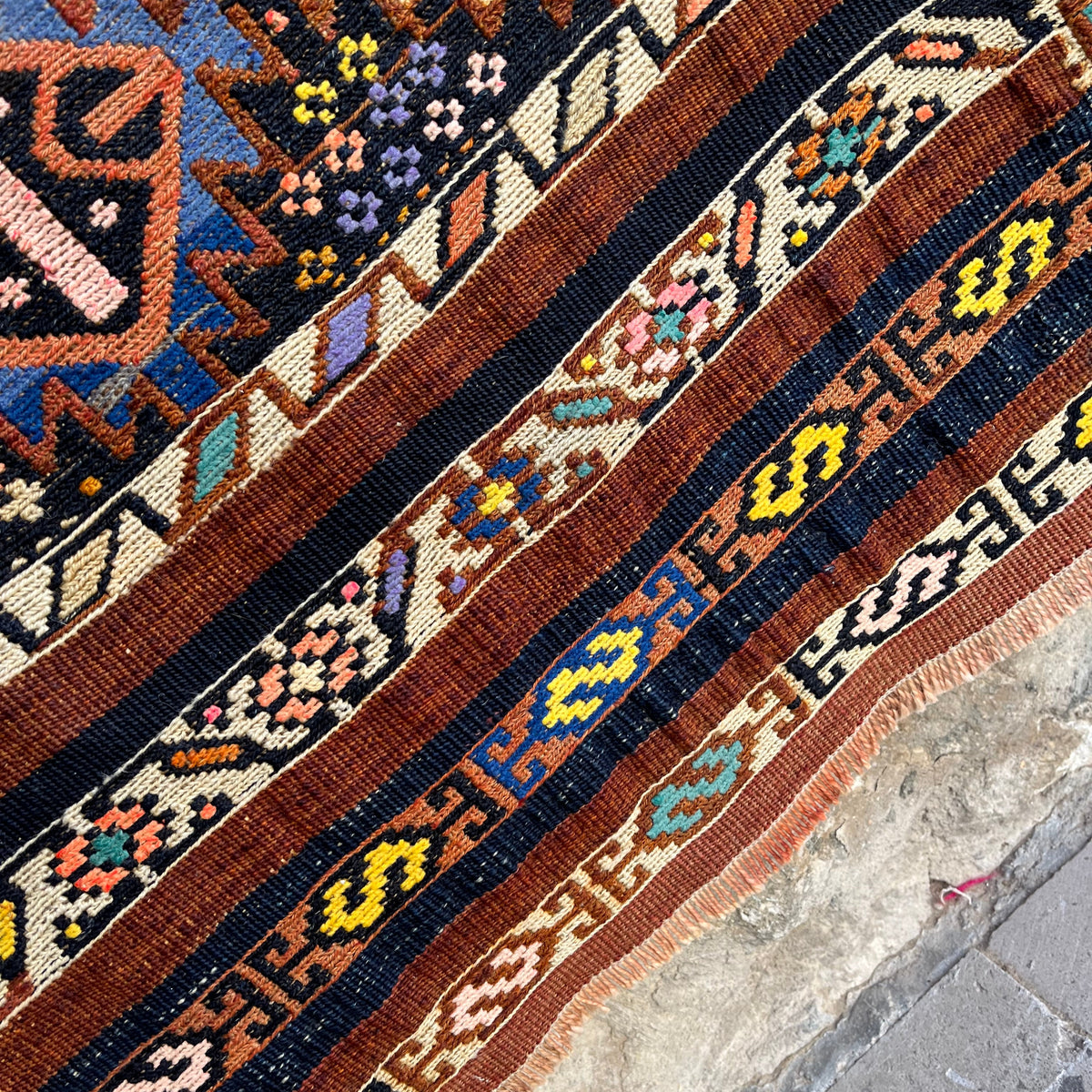 Close-up of the brown vintage mini kilim runner rug showing traditional details, flatweave construction, wool and cotton and low pile.