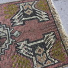 Close-up of the red vintage Turkish mini rug showing traditional details, hand-knotted weave, wool and cotton and low pile.