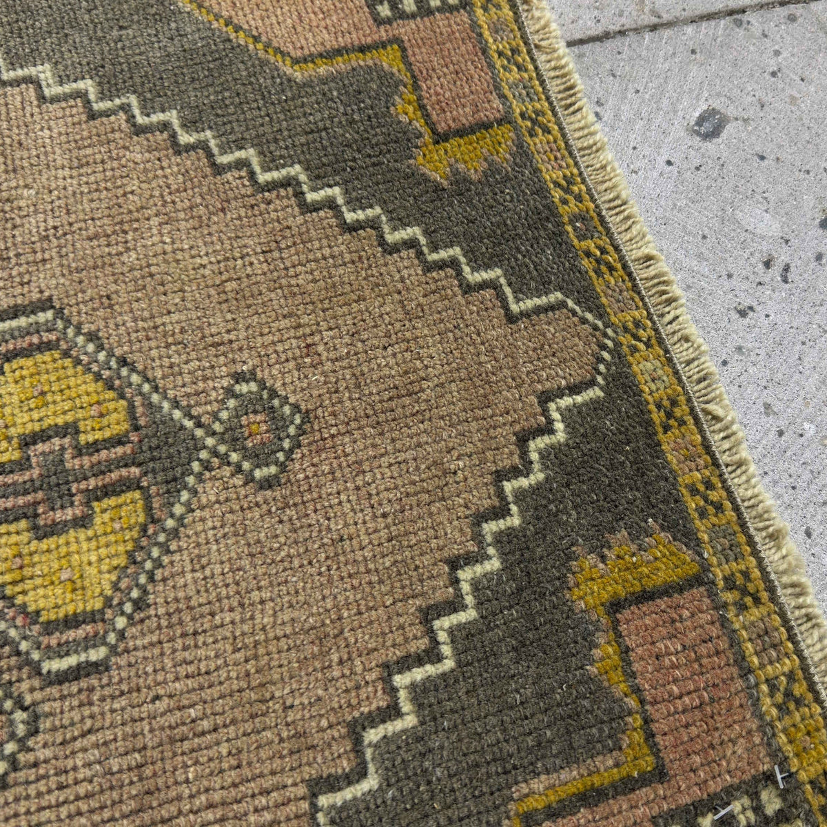 Close-up of the yellow vintage Turkish mini rug showing traditional details, hand-knotted weave, wool and cotton and low pile.