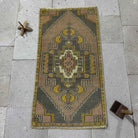 Yellow 2' x 3' vintage Turkish mini rug in wool and cotton, shown on the floor.