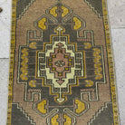 1970s yellow vintage Turkish mini rug with traditional design, hand-knotted weave and low pile.