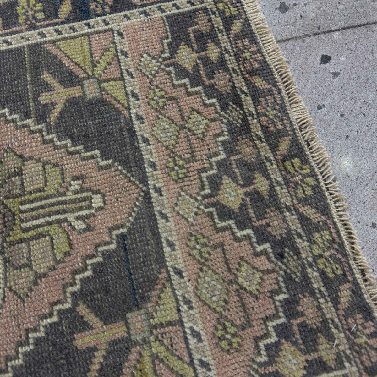 Close-up of the pink vintage Turkish mini runner showing traditional details, hand-knotted weave, wool and cotton and low pile.