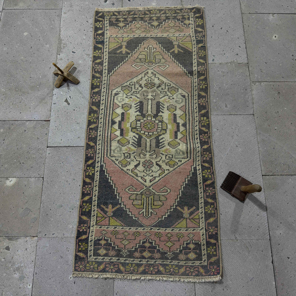 Pink 2' x 4' vintage Turkish mini runner in wool and cotton, shown on the floor.