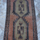Close-up of the orange vintage Turkish mini runner showing traditional details, hand-knotted weave, wool and cotton and low pile.