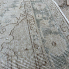 Close-up of the beige vintage Turkish muted rug showing neutral details, hand-knotted weave, wool and cotton and low pile.