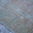 Pink 3' x 5' vintage Turkish neutral rug in wool and cotton, shown on the floor.