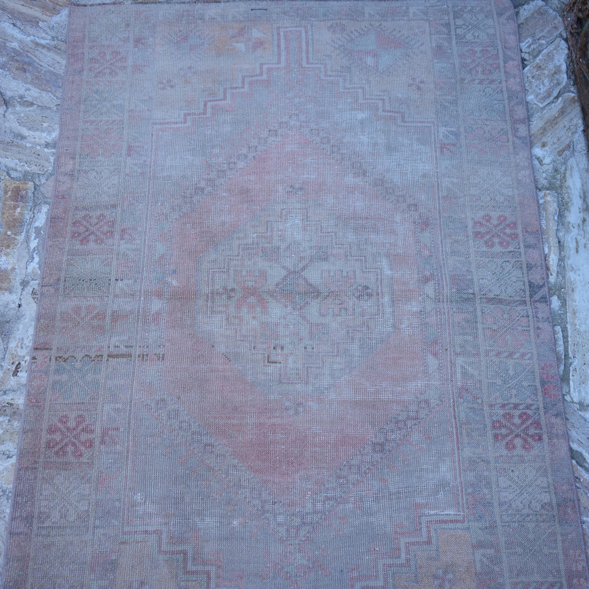Close-up of the pink vintage Turkish neutral rug showing neutral details, hand-knotted weave, wool and low pile.