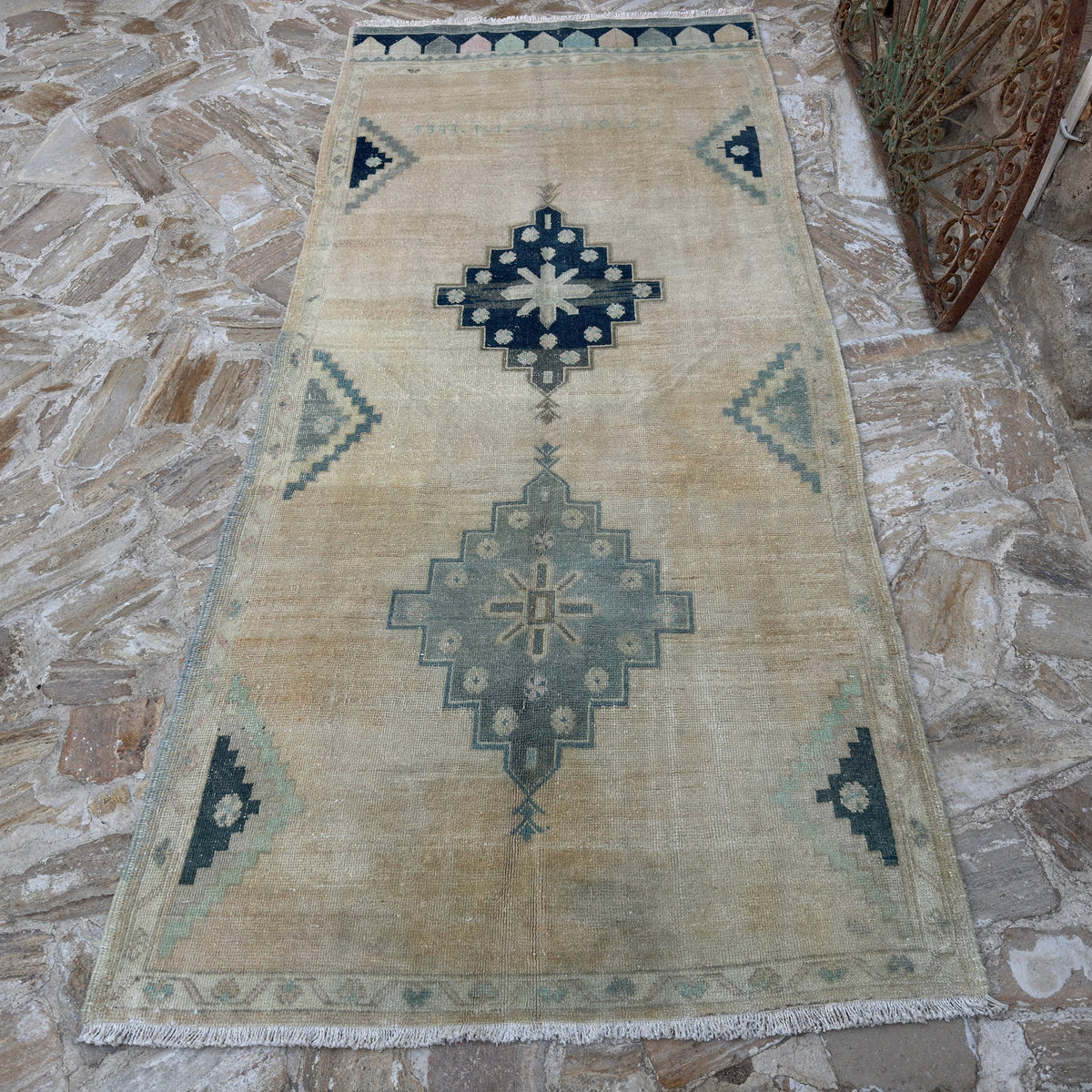 Close-up of the beige vintage Turkish neutral wool rug showing neutral details, hand-knotted weave, wool and cotton and low pile.
