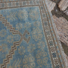 Close-up of the pale blue vintage Turkish oriental rug showing traditional details, hand-knotted weave, wool and cotton and low pile.