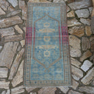 Pale Blue 2' x 4' vintage Turkish oriental rug in wool and cotton, shown on the floor.