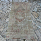 Pale Red 3' x 6' vintage Turkish oriental rug in wool and cotton, shown on the floor.