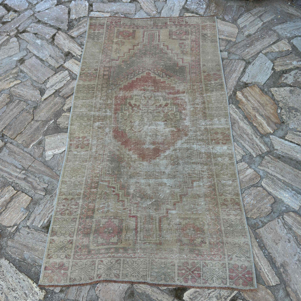 Pale Red 3' x 6' vintage Turkish oriental rug in wool and cotton, shown on the floor.