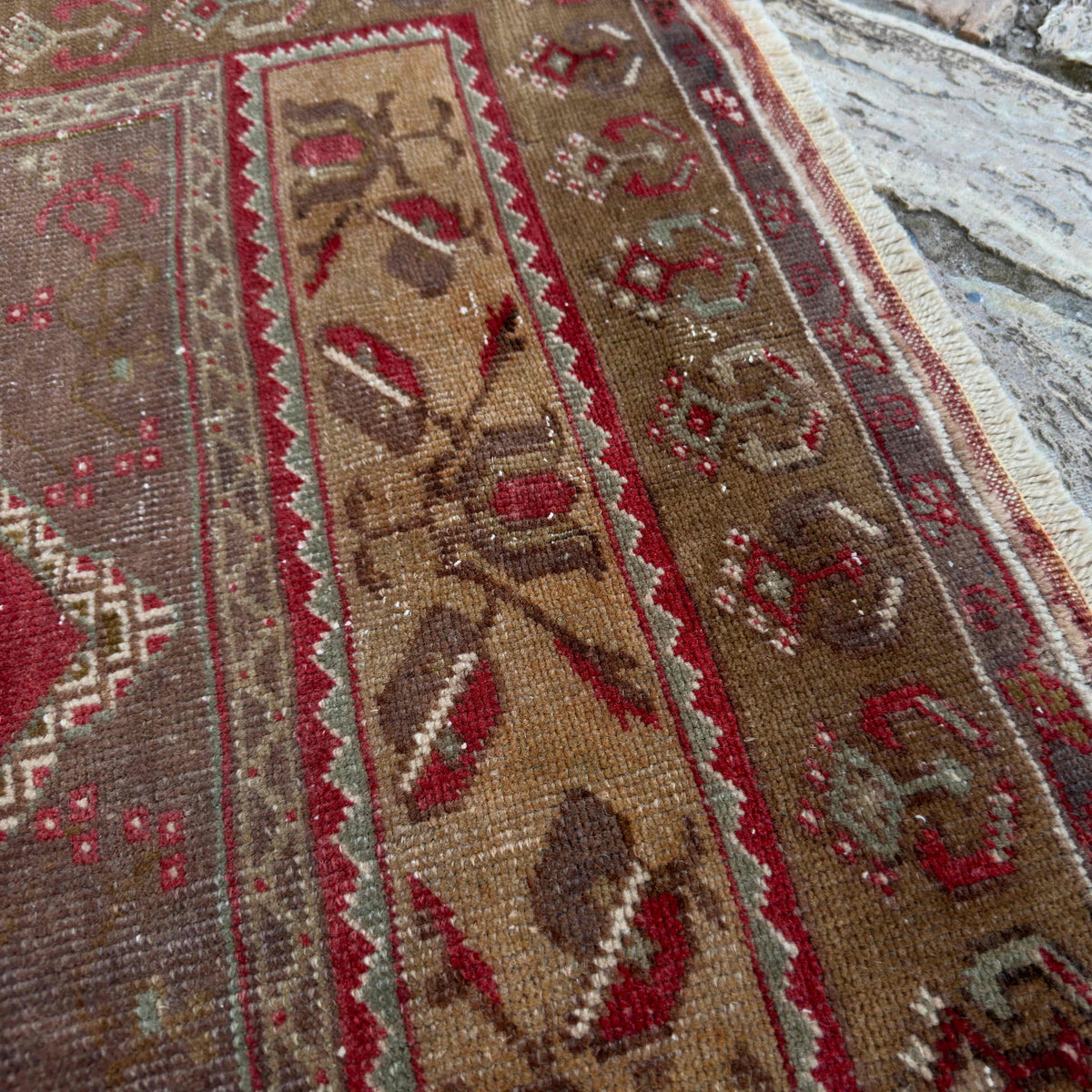 Close-up of the red vintage Turkish oriental rug showing traditional details, hand-knotted weave, wool and cotton and low pile.