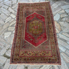 Red 3'x 6' vintage Turkish oriental rug in wool and cotton, shown on the floor.