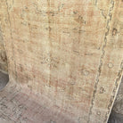 Beige 5' x 8' vintage Turkish oriental rug in wool and cotton, shown on the floor.
