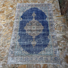 Blue 6' x 10' vintage Turkish oriental rug in wool and cotton, shown on the floor.
