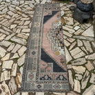 Pink 3' x 8' vintage Turkish oriental runner rug in wool and cotton, shown on the floor.