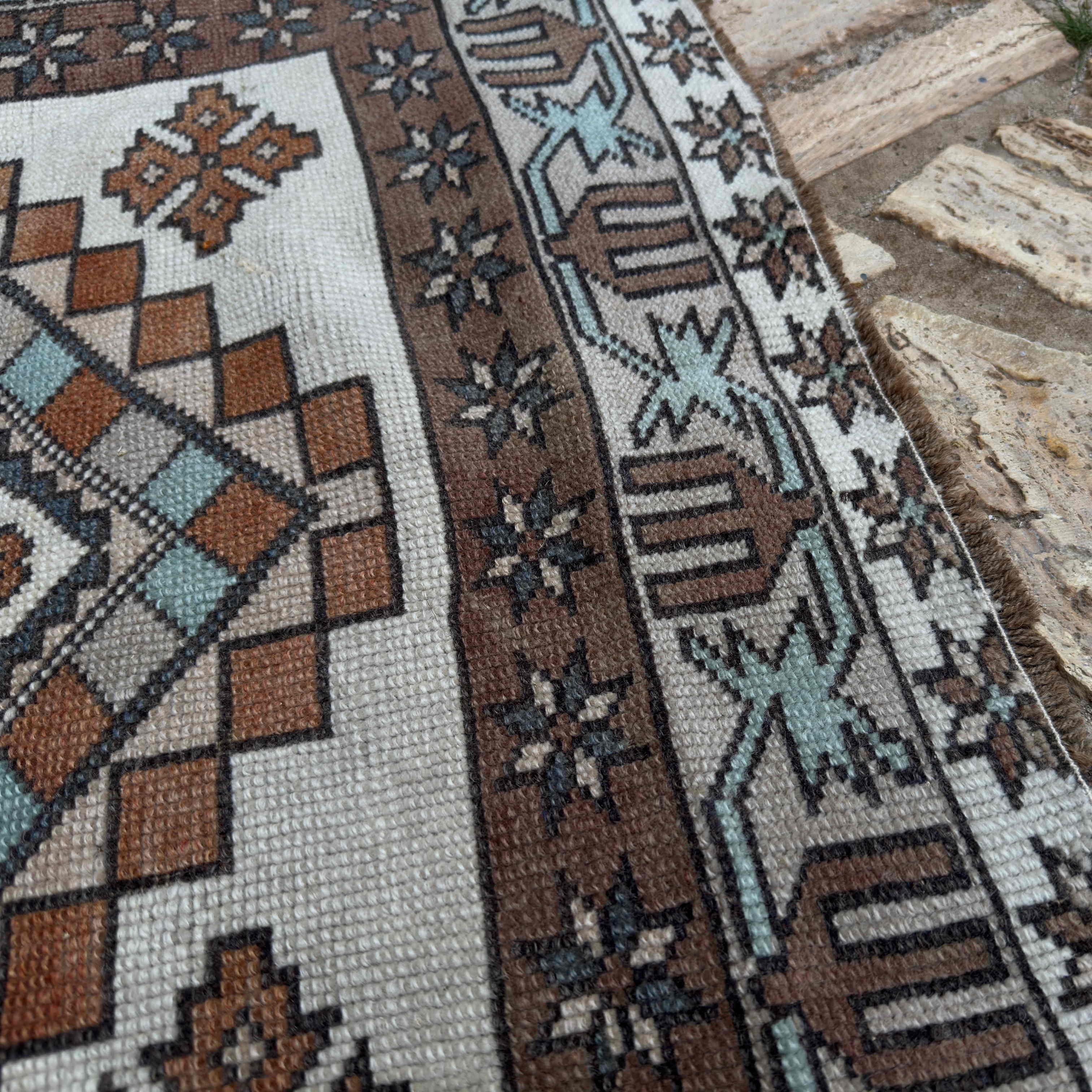 Close-up of the brown vintage Turkish oushak rug showing medallion details, hand-knotted weave, wool and cotton and low pile.