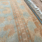 Close-up of the blue vintage Turkish oushak rug showing traditional details, hand-knotted weave, wool and cotton and low pile.