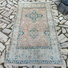 Pink 4' x 7' vintage Turkish oushak rug in wool and cotton, shown on the floor.