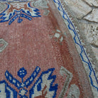 Close-up of the pale red vintage Turkish oushak runner rug showing oushak details, hand-knotted weave, wool and cotton and low pile.