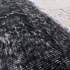 Close-up of the black vintage Turkish overdyed rug showing overdyed details, hand-knotted weave, wool and cotton and low pile.