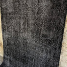 1970s black vintage Turkish overdyed rug with overdyed design, hand-knotted weave and low pile.