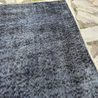 Close-up of the black vintage Turkish overdyed rug, hand-knotted weave, wool and cotton and low pile.