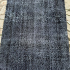 1970s black vintage Turkish overdyed rug, hand-knotted weave and low pile.