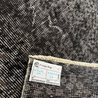 Close-up of the black vintage Turkish overdyed rug showing overdyed details, hand-knotted weave, wool and cotton and low pile.