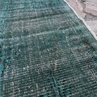 Close-up of the blue vintage Turkish overdyed rug showing overdyed details, hand-knotted weave, wool and cotton and low pile.