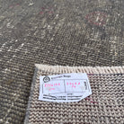 Close-up of the gray vintage Turkish overdyed rug showing overdyed details, hand-knotted weave, wool and cotton and low pile.