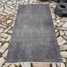 Gray 4' x 7' vintage Turkish overdyed rug in wool and cotton, shown on the floor.