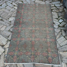 Gray 4' x 7' vintage Turkish overdyed rug in wool and cotton, shown on the floor.