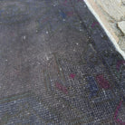 Close-up of the grey vintage Turkish overdyed rug showing overdyed details, hand-knotted weave, wool and cotton and low pile.
