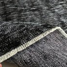 Close-up of the black vintage Turkish overdyed rug showing overdyed details, hand-knotted weave, wool and cotton and low pile.
