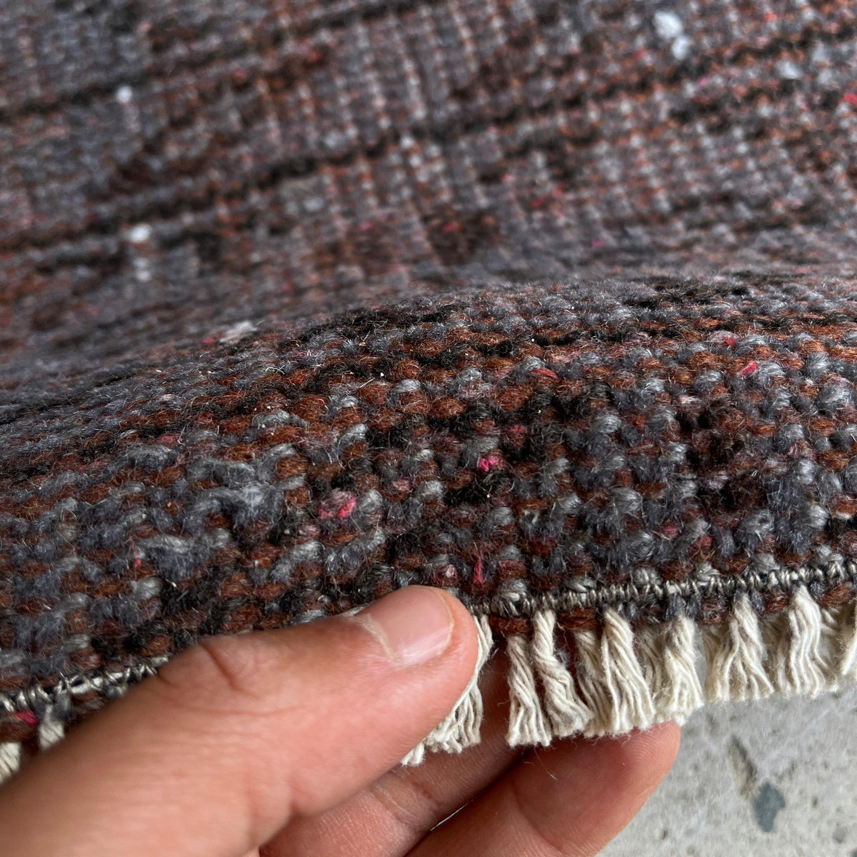 Close-up of the gray vintage Turkish overdyed rug showing overdyed details, hand-knotted weave, wool and cotton and low pile.