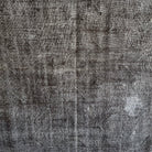 Gray 5' x 9' vintage Turkish overdyed rug in wool and cotton, shown on the floor.