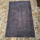 Gray 6' x 10' vintage Turkish overdyed rug in wool and cotton, shown on the floor.