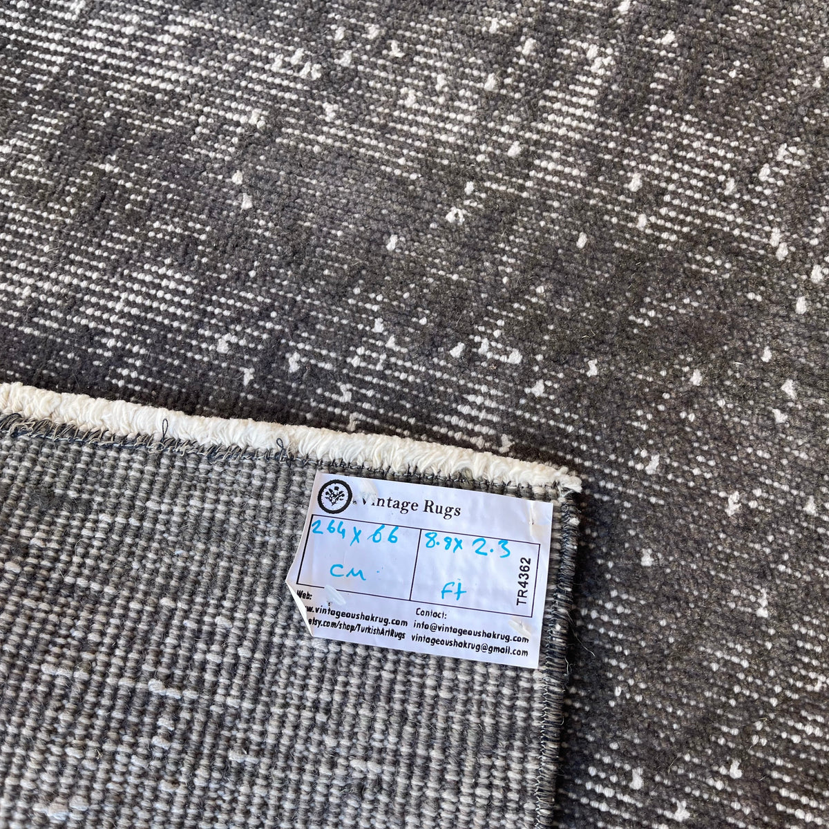 Close-up of the gray vintage Turkish overdyed runner rug showing overdyed details, hand-knotted weave, wool and cotton and low pile.