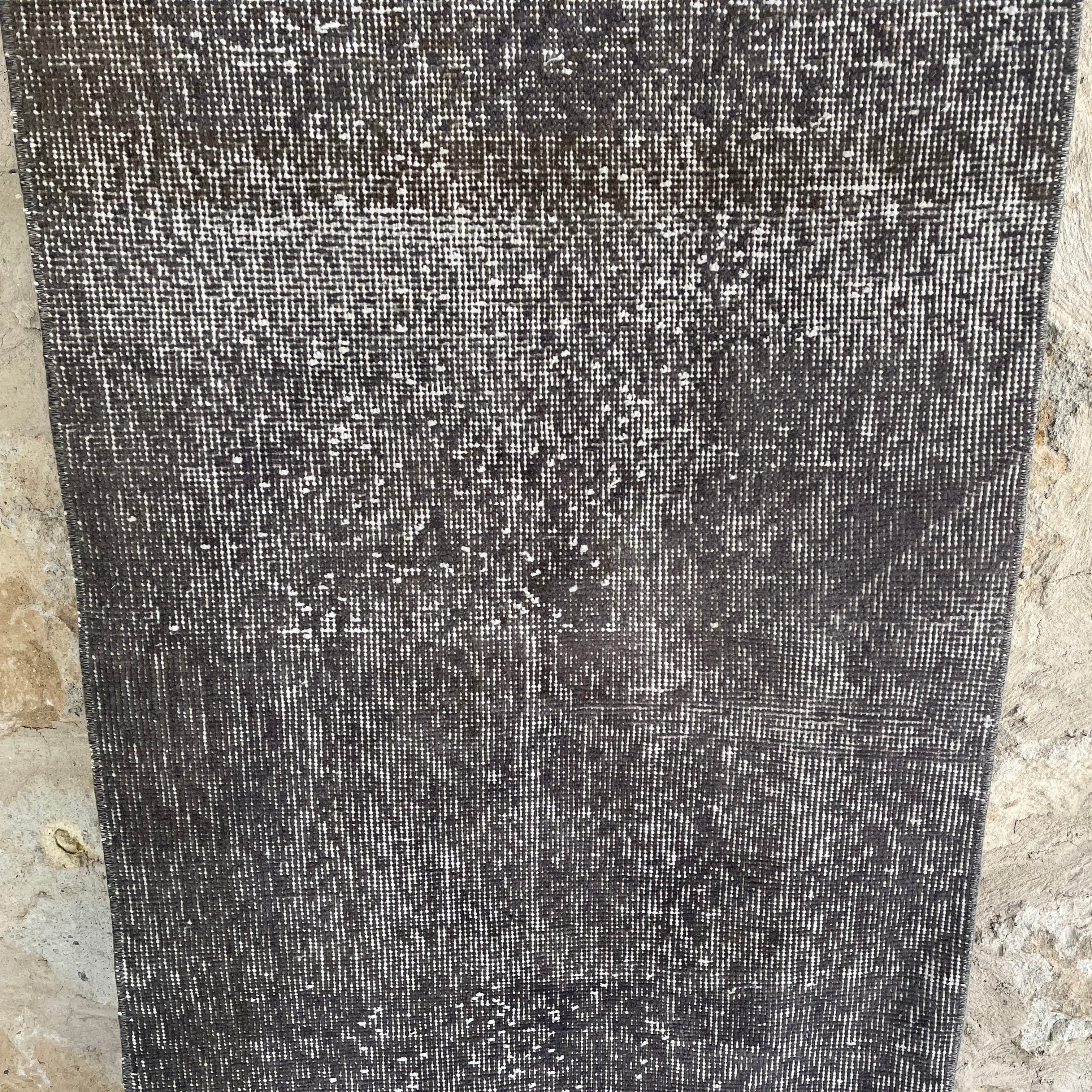Gray 2' x 9' vintage Turkish overdyed runner rug in wool and cotton, shown on the floor.