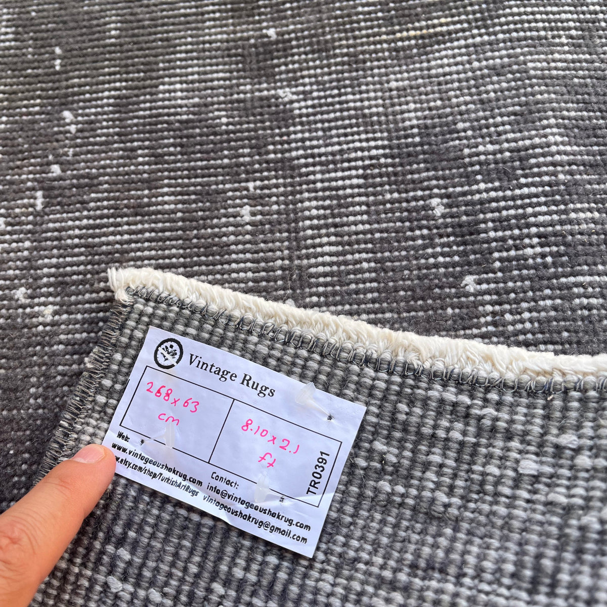 Close-up of the gray vintage Turkish overdyed runner rug showing overdyed details, hand-knotted weave, wool and cotton and low pile.