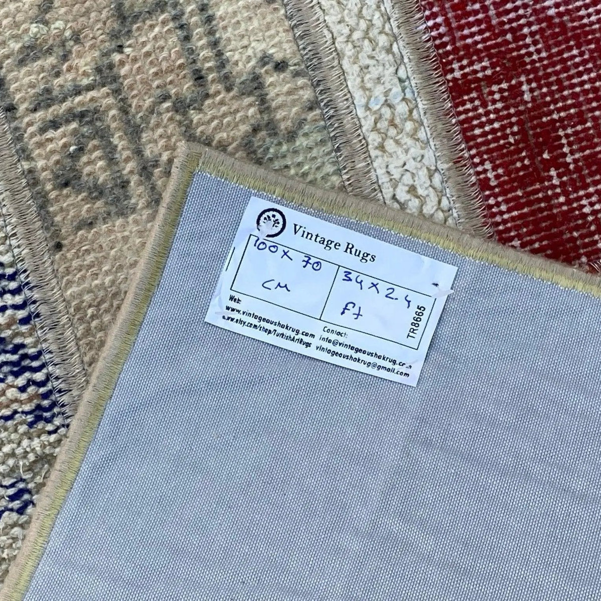 Close-up of the red vintage Turkish patchwork rug showing patchwork details, hand-knotted weave, wool and cotton and low pile.