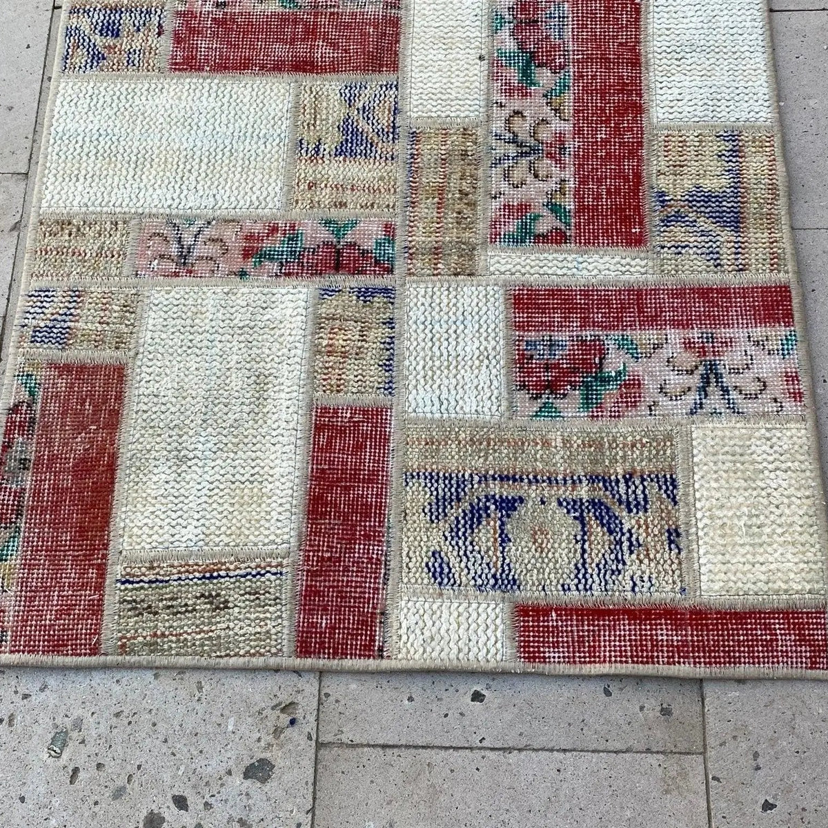 Red 2' x 3' vintage Turkish patchwork rug in wool and cotton, shown on the floor.
