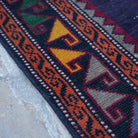 Purple 4' x 10' vintage Turkish persian rug in wool and cotton, shown on the floor.