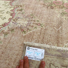 Close-up of the pink vintage persian rug showing medallion details, hand-knotted weave, wool and cotton and low pile.