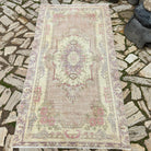 Pink 4' x 6' vintage persian rug in wool and cotton, shown on the floor.