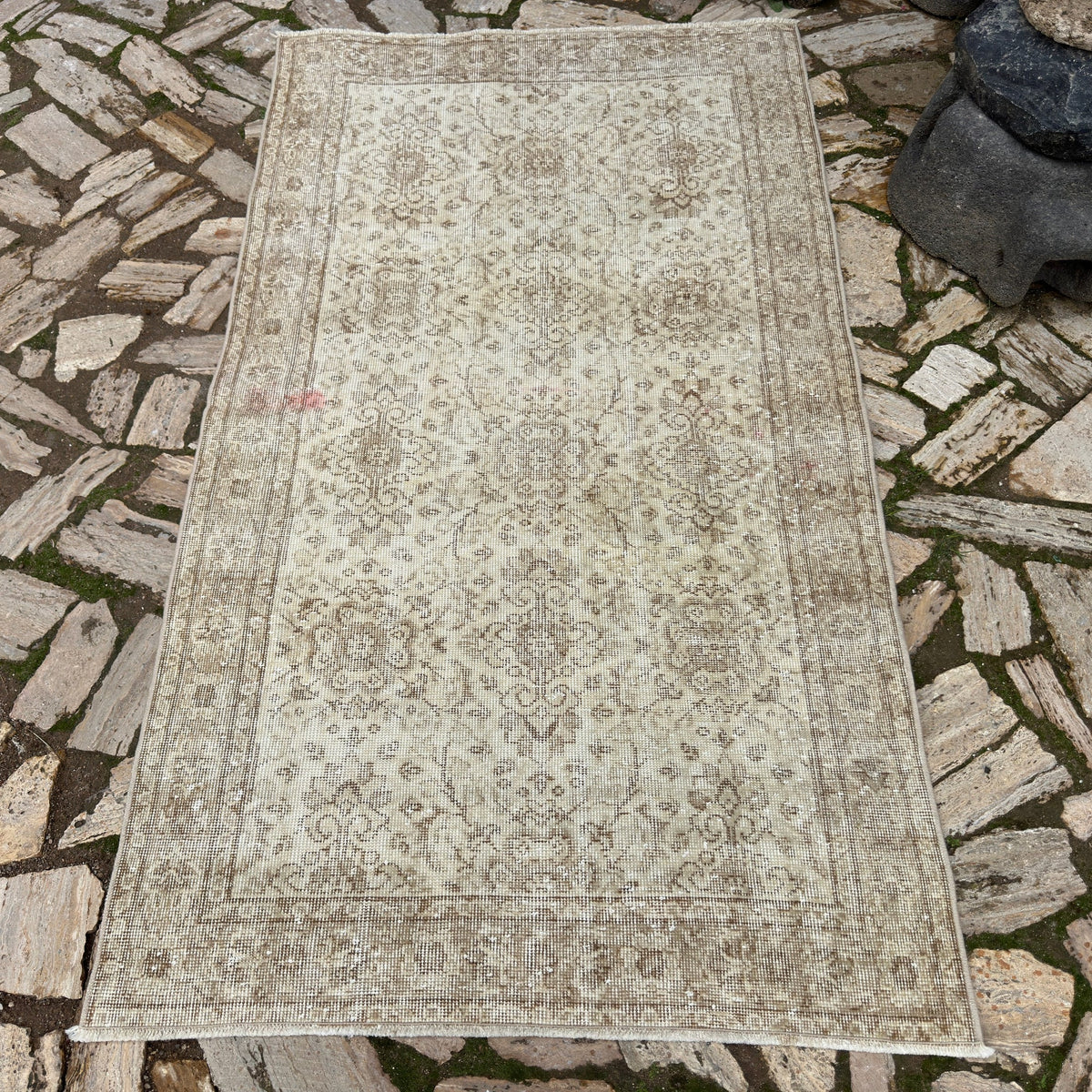 Beige 4' x 7' vintage persian rug in wool and cotton, shown on the floor.