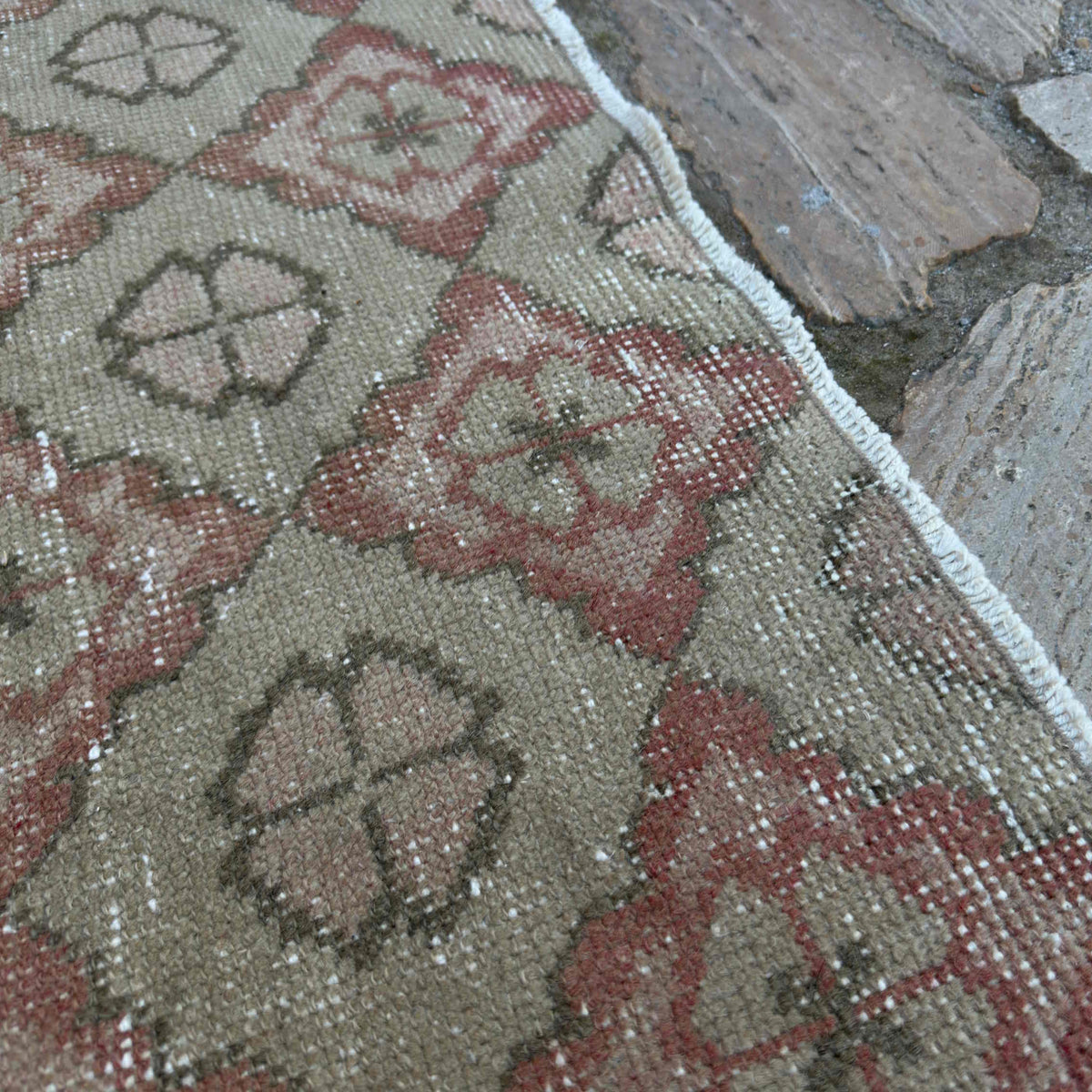 Close-up of the beige vintage Turkish persian rug showing traditional details, hand-knotted weave, wool and cotton and low pile.